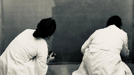 black and white picture of two conservators in lab coats working on painting.jpeg
