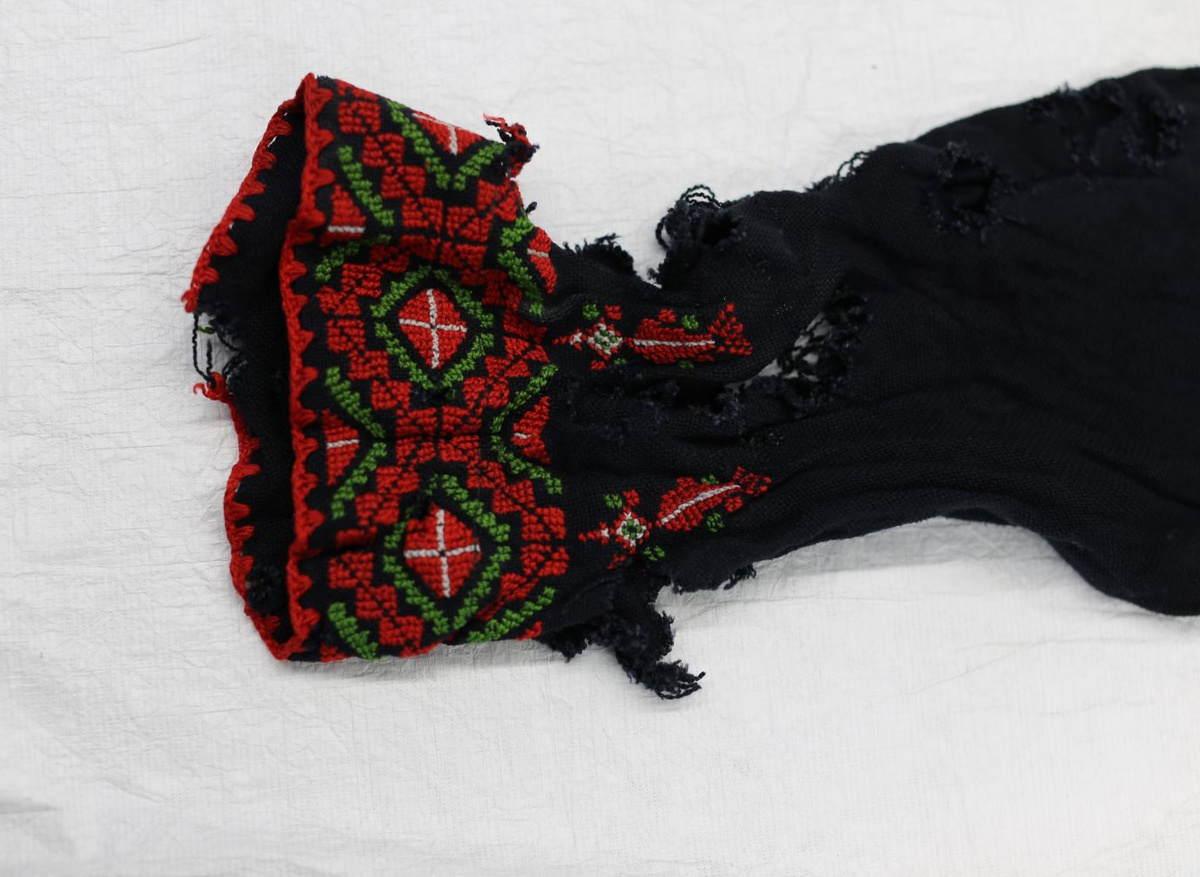 The shredded sleeve cuff of the child’s dress