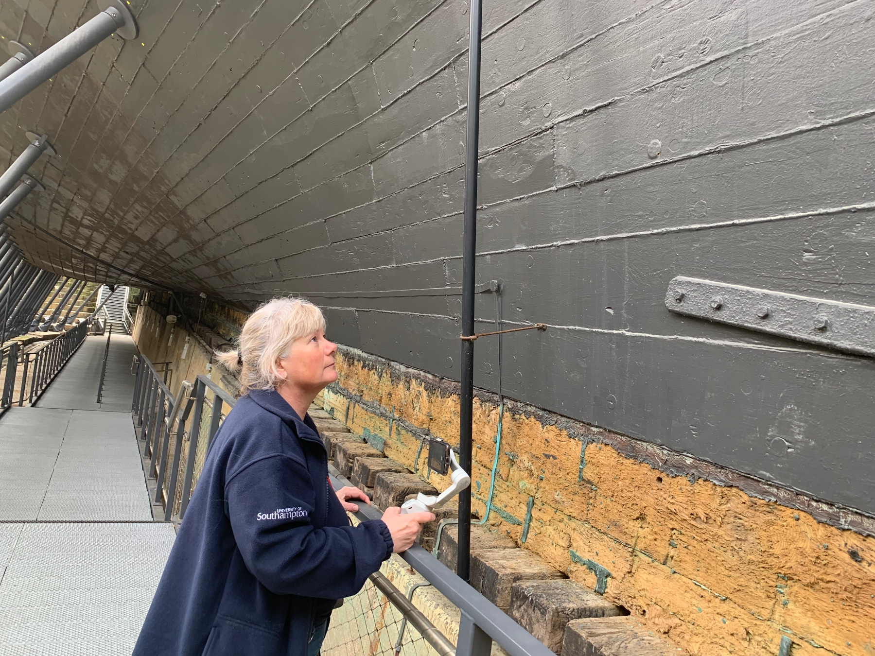 Sam Hambrook examining hull of HMS Victory_Credit_University of Southampton.jpeg