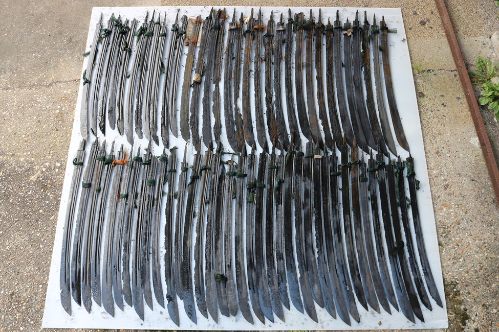 68 sabre blades laid out side by side on the ground. © Historic England  #Rooswijk1740 Project..jpg