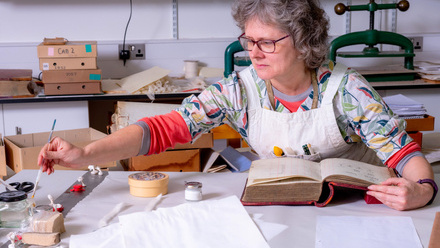 conservator working with brush to repair book and ceramics. Credit Steven Wood-Matthews, Worcestershire Archive and Archaeology Service (2).jpg