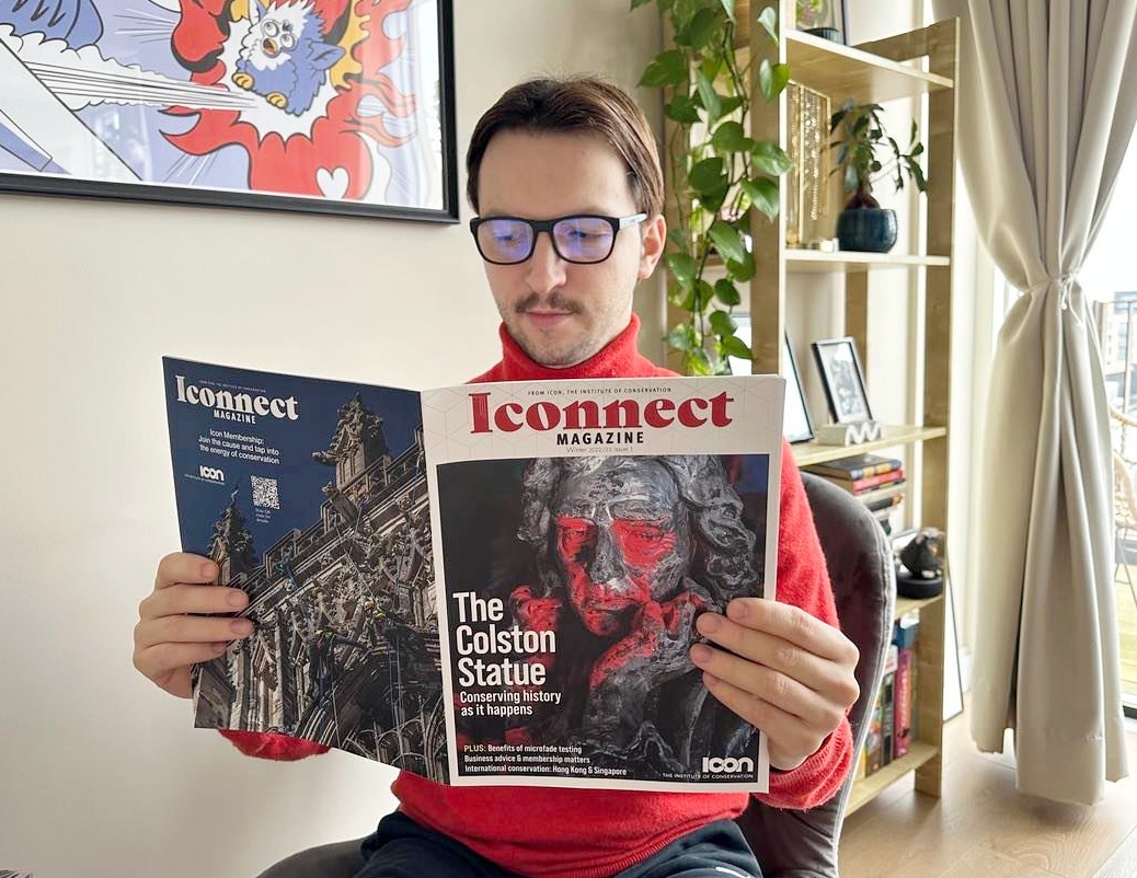 person reading 1st issue of Iconnect Magazine in home setting.jpg
