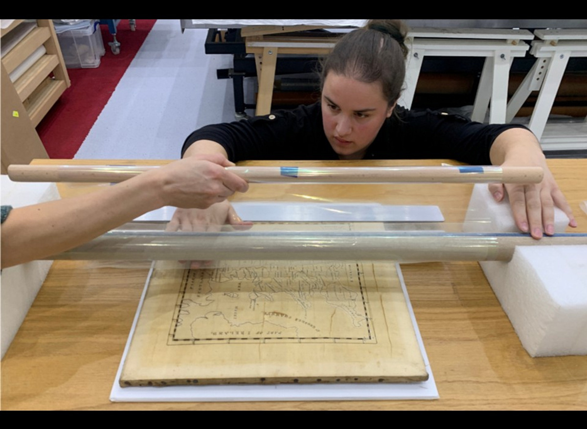 Teaching a trainee conservator how to lay down a support over a fragile embroidery