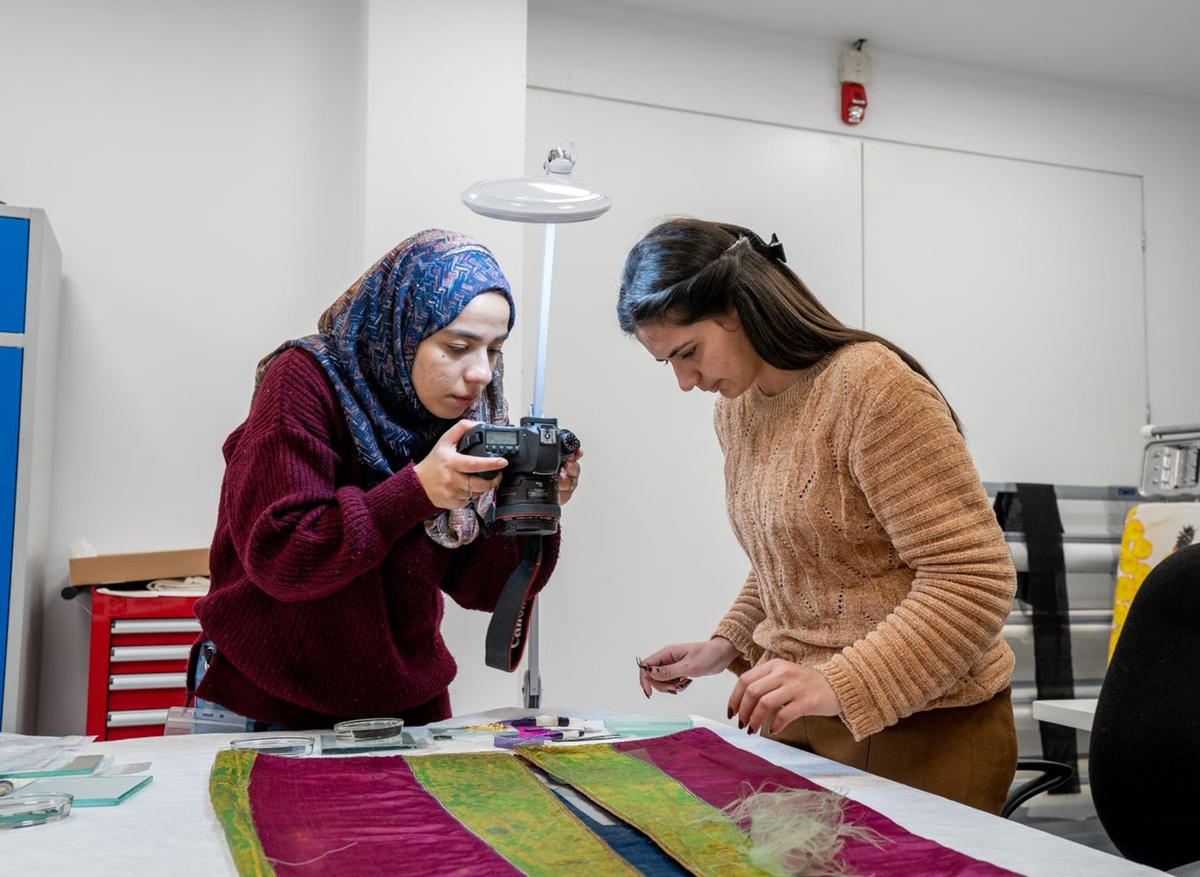 Bara and Salma photograph a jellayah as part of the documentation process