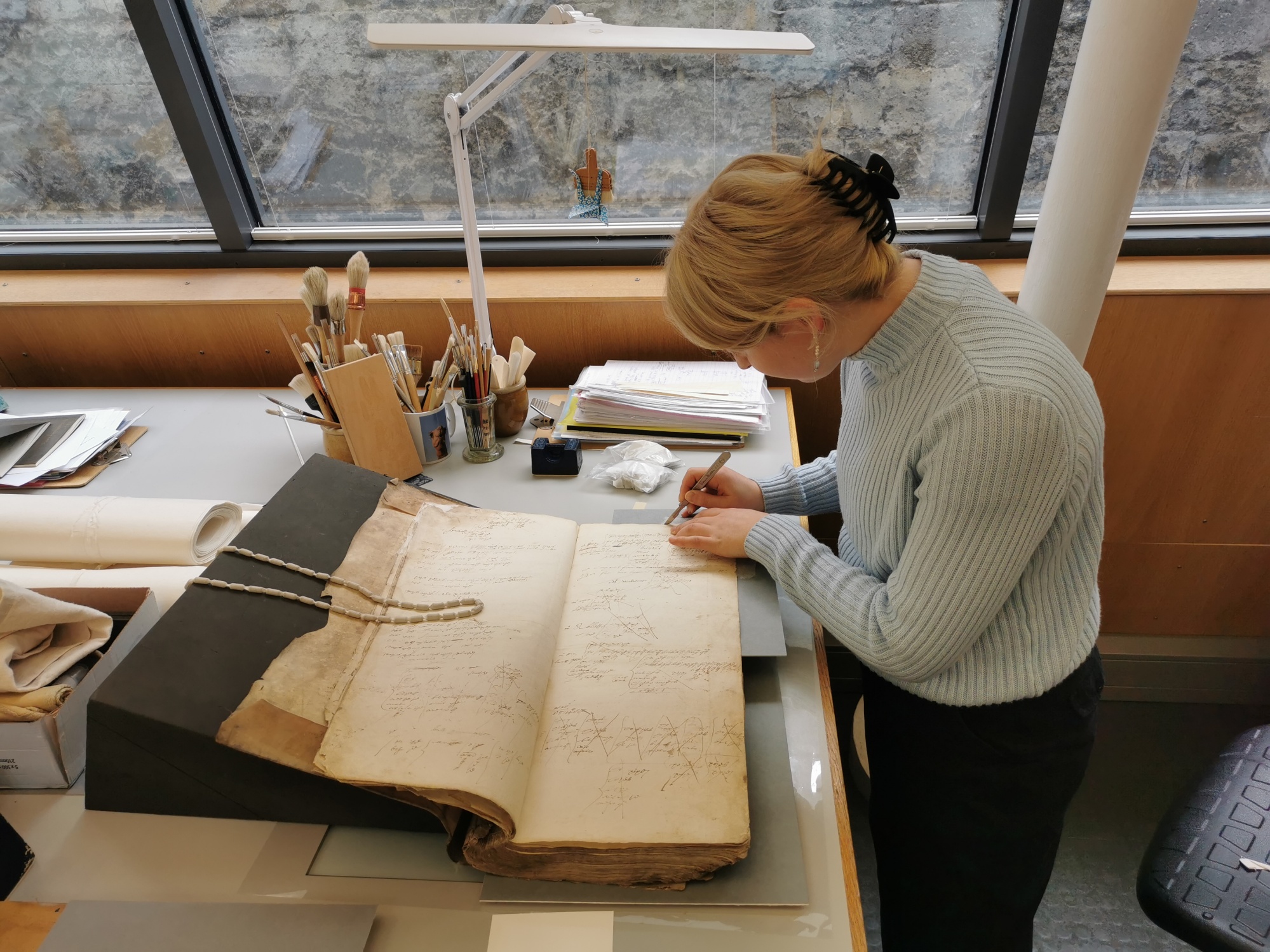 young conservator Icon intern work bench book and paper conservation Credit Anna Gallwey1.jpg