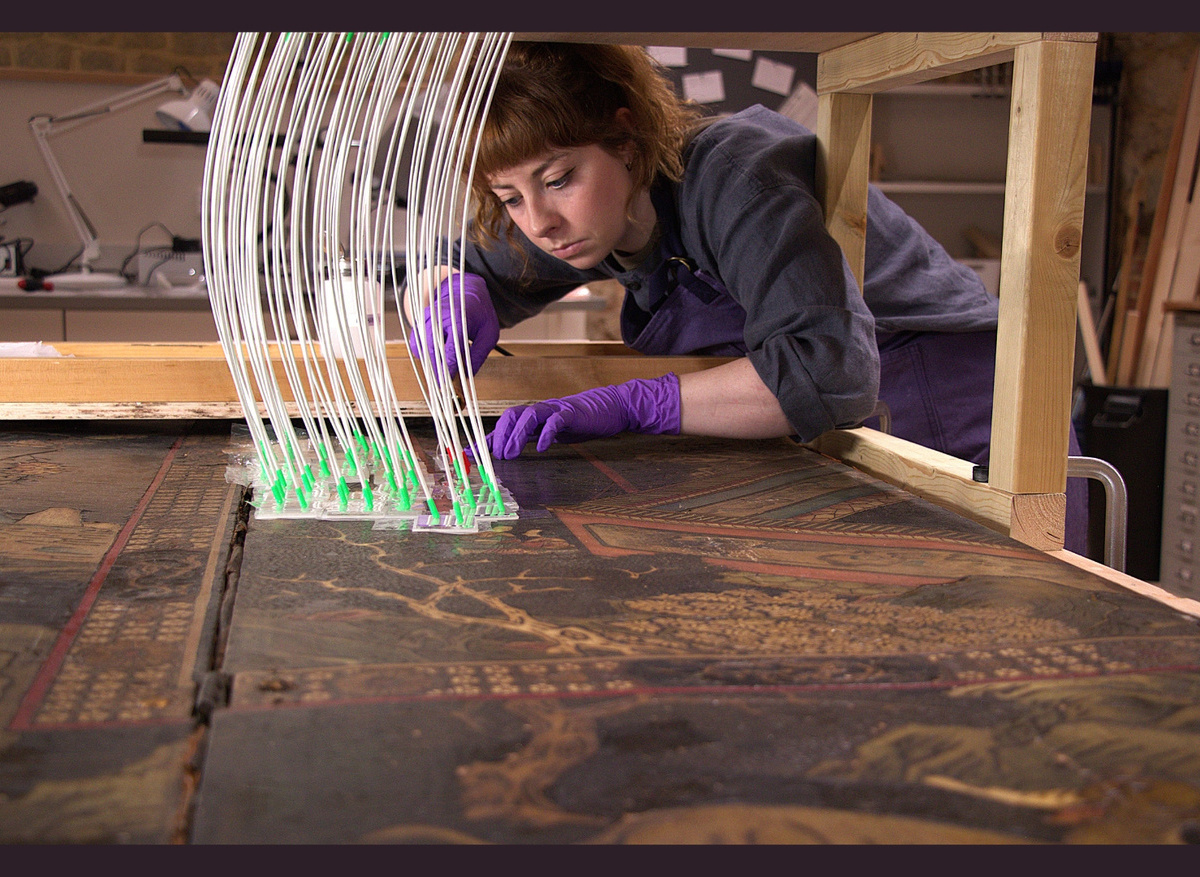  Mid-treatment, carefully warming the Chinese incised polychrome (kaun cai) lacquer surface with a heated spatula. 