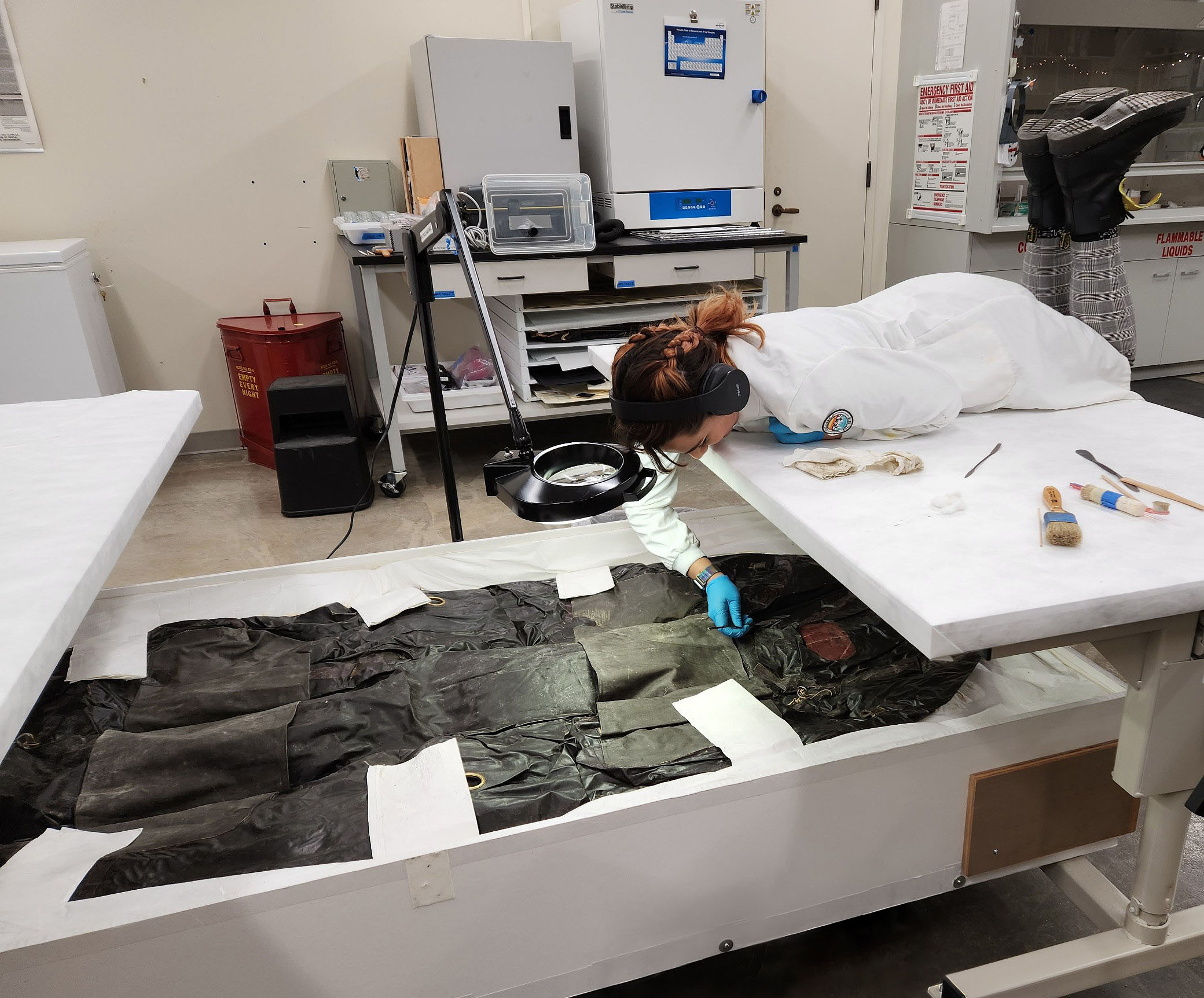 Conservator on conservation bench cleaning rubber aircraft costume. Credit Sejal Goel, Missouri Historical Society.jpg